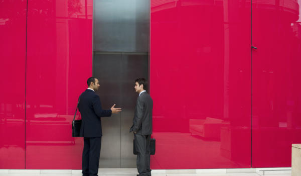 Two Businessmen Talking by Elevator